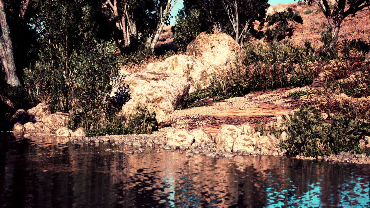 Tranquil riverside landscape with lush greenery and rocky features at sunset