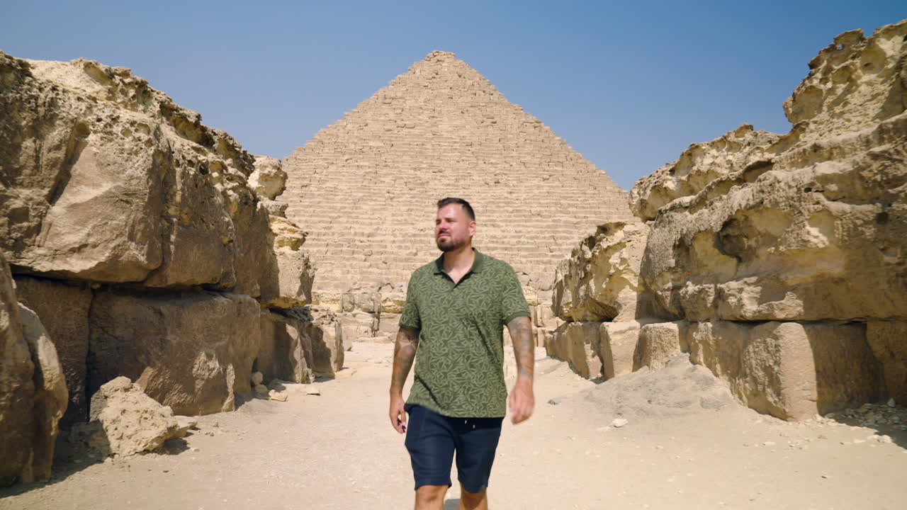 A Man Tourist Exploring Giza Plateau With Limestone Rock Formation In Giza, Egypt. Pullback Shot