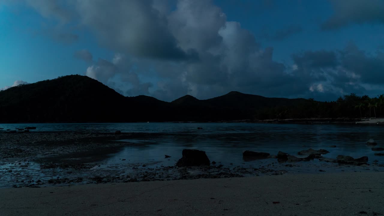 Marea crescente su un'isola tropicale, dal giorno alla notte, nuvole nel cielo, timelapse.