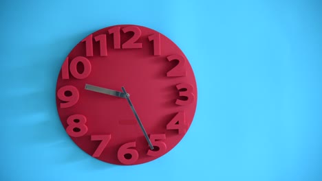 time lapse of red clock on blue wall