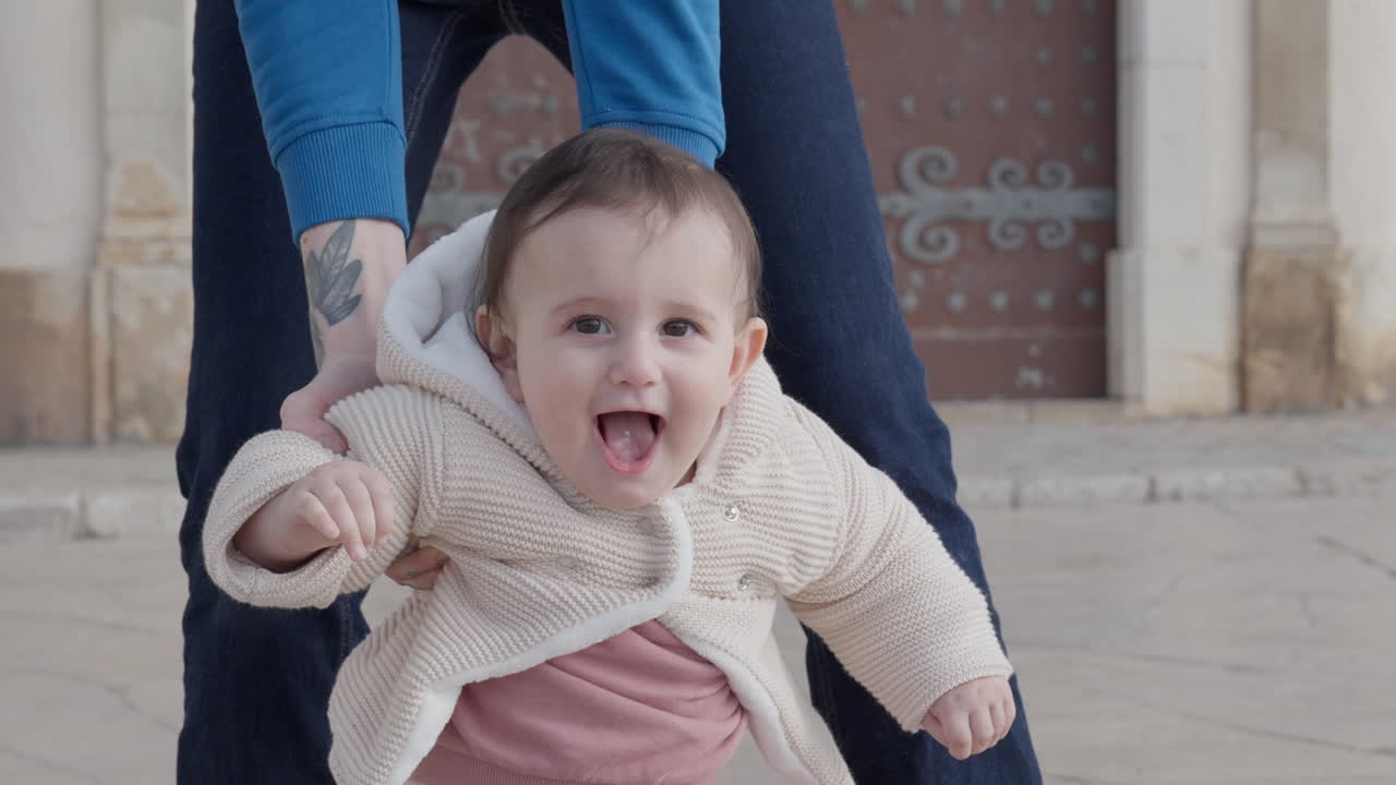 Happy baby in mothers arms learns to walk