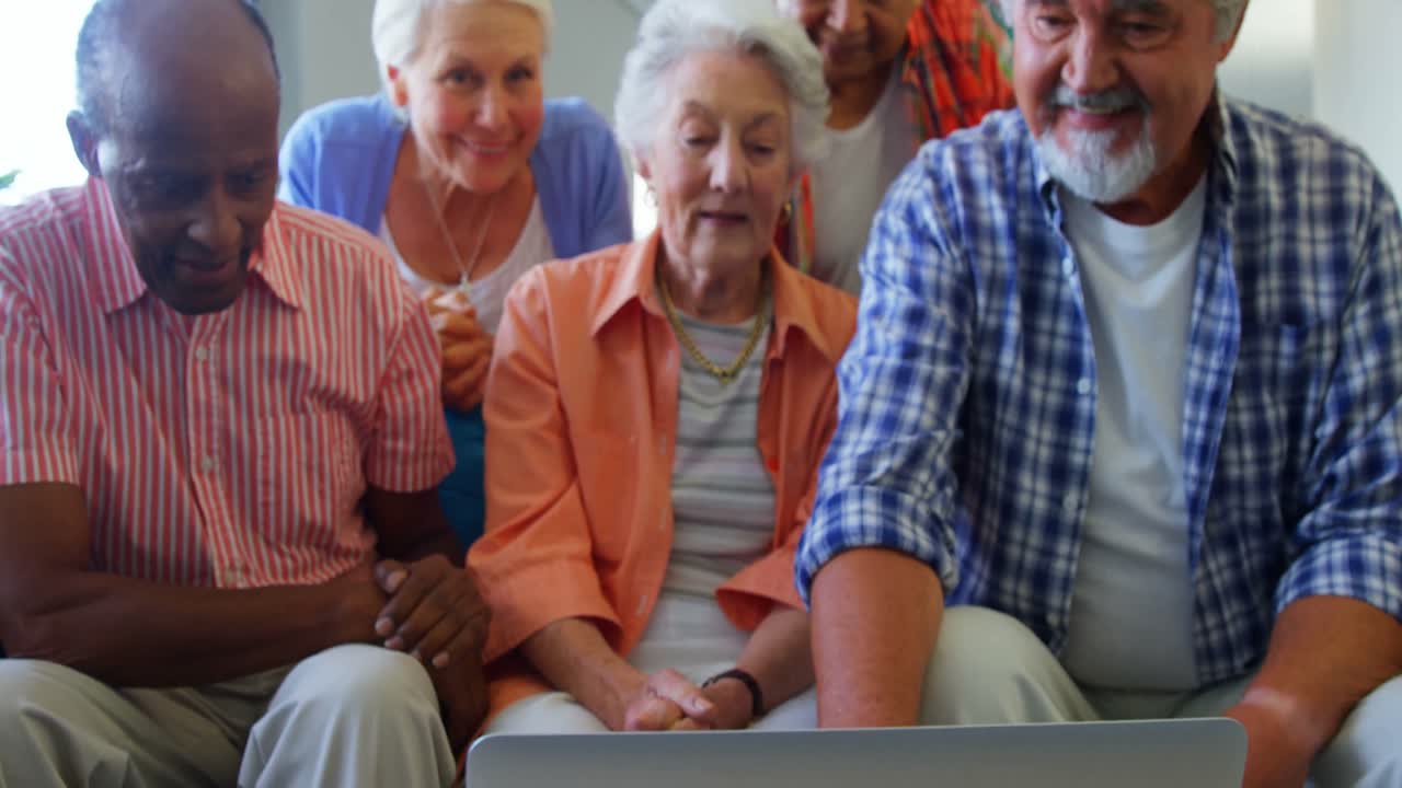 amigos mayores felices divirtiéndose mientras usan computadora portátil 4k