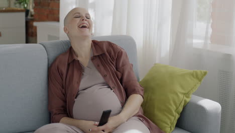 happy pregnant woman watching tv