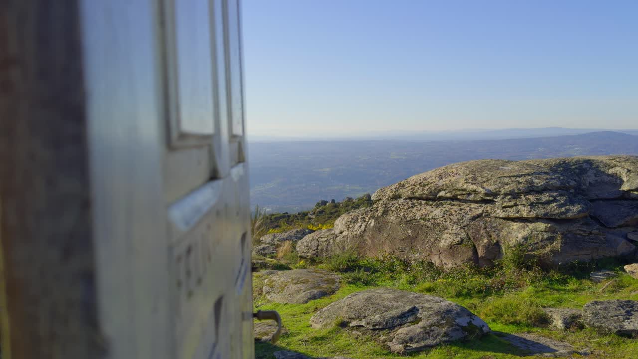cerrar la puerta de madera blanca que muestra vistas increíbles en la cima de una montaña