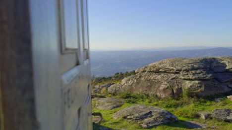 cerrar la puerta de madera blanca que muestra vistas increíbles en la cima de una montaña