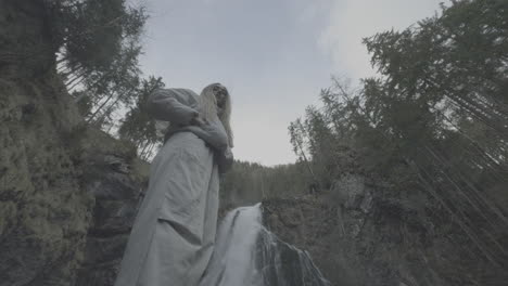 woman in front of waterfall in forest