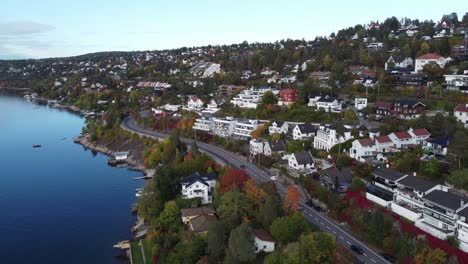 aerial view of katten beach houses near oslo, you can see the norwegian colored houses and cars driving on the road near the beach