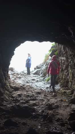 people exploring a cave entrance