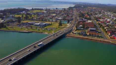 Vista-De-Pájaro-De-Los-Automóviles-Que-Conducen-En-El-Puente-De-Windang-Road-Y-El-Suburbio-De-Windang-En-Nsw,-Australia