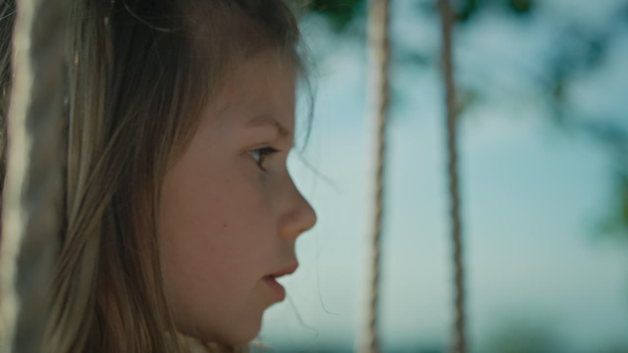 un primer plano de una chica caucásica jugando con burbujas y balanceándose.