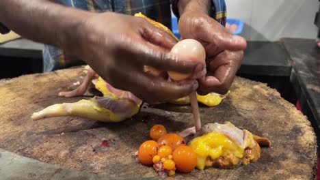 Close-up-of-mans-hands-with-machete-chopping-chicken-meat-on-wooden-cutting-board