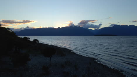 reveal of waves on calm blue lake te anau with mountains in the background