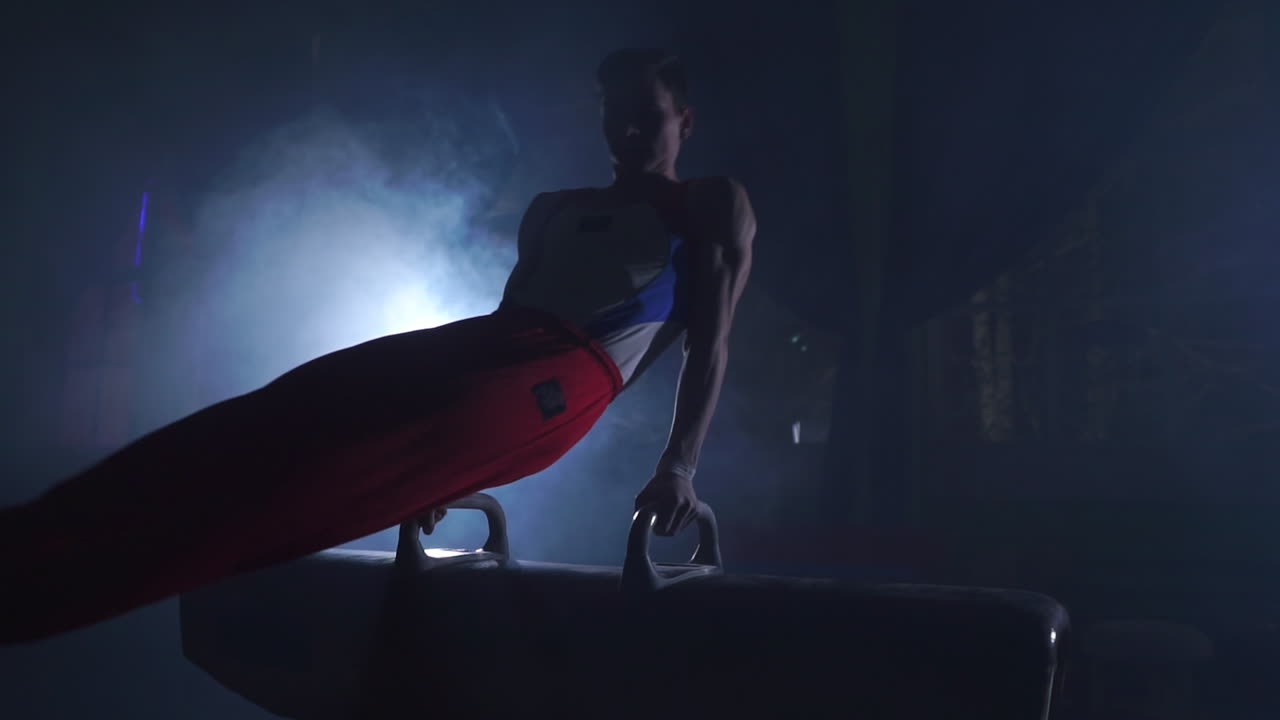 gimnasta masculino montando y desmontando caballo de pommel. deporte olímpico en un entorno contemporáneo. cámara lenta