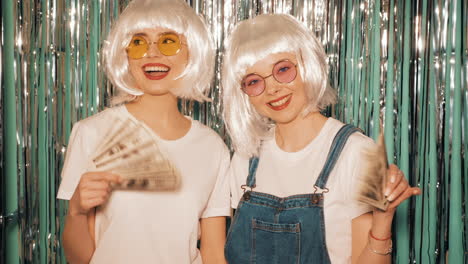 two friends celebrating with money