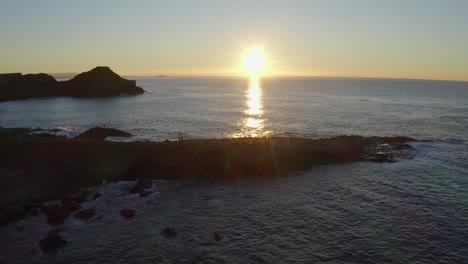 static aerial shot of the horizon featuring the sunset silhouetting the coastline at giant's causeway.