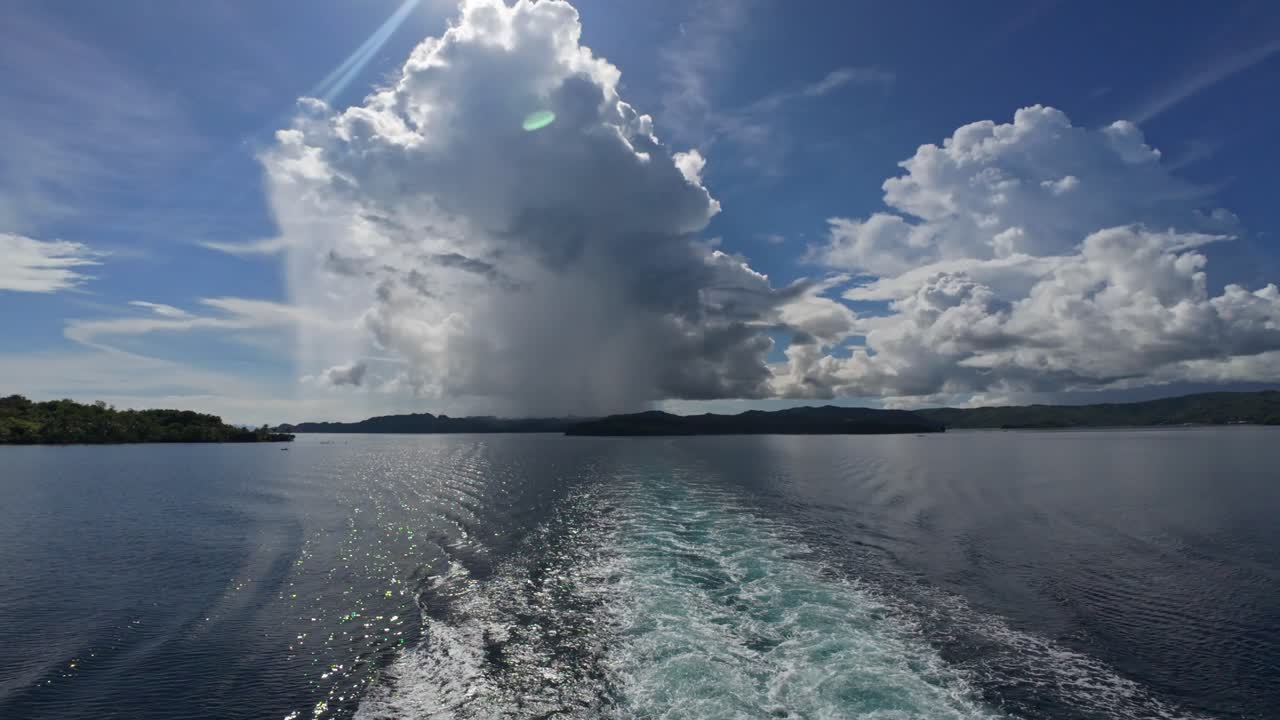 Waves trailing behind ferry under cloudy skies as it nears Dinagat Islands, Philippines.