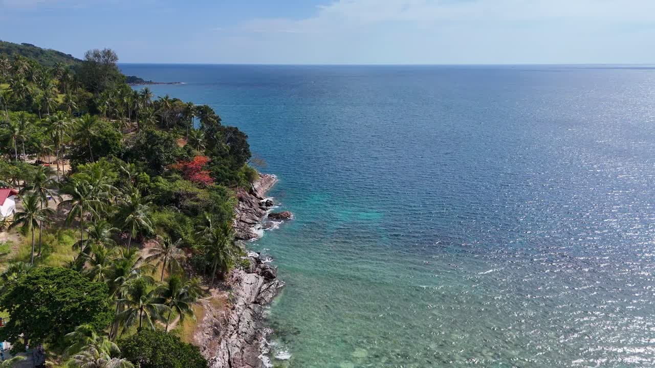 드론 영상은 태국 푸켓의 놀라운 해안선을 포착합니다. 밝은 낮빛 아래 울창한 초록색과 은 파란 물을 보여줍니다.