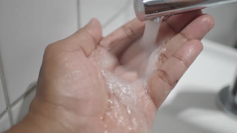 washing hands under a running faucet