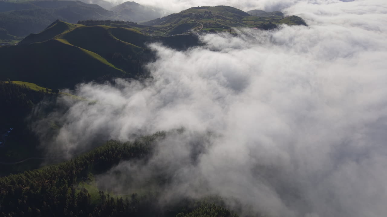 Stunning aerial view of a sea of clouds flowing over the forests and volcanic hills of gran canaria