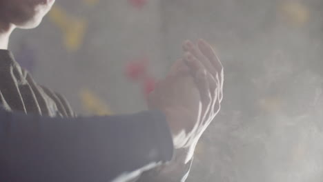 Close-Up-Shot-Of-An-Unrecognizable-Sportsman-Clapping-And-Rubbing-Hands-Covered-With-White-Chalk-Powder-Before-Climbing-In-Indoor-Bouldering-Gym