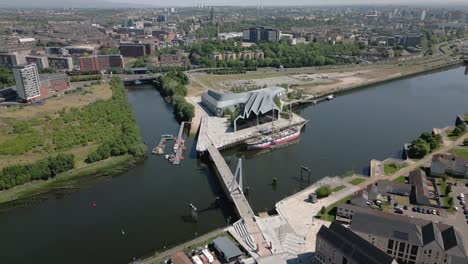 aerial fly straight towards riverside museum before flying over the govan area of glasgow, scotland, uk