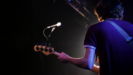 Hombre-Tocando-La-Guitarra-En-El-Escenario-De-Un-Concierto