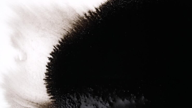 Gocce d'inchiostro nero su sfondo bianco