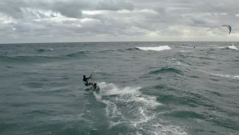 cerrar video aéreo de kiteboarder haciendo gran truco de una ola