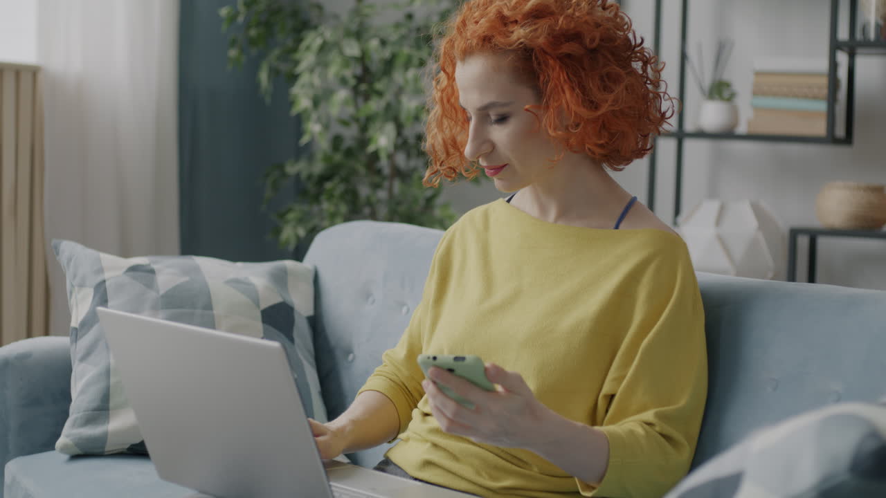 mujer trabajando desde casa en portátil y teléfono
