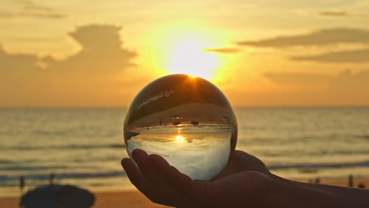 la mano sostenía una bola de cristal en la puesta del sol.
