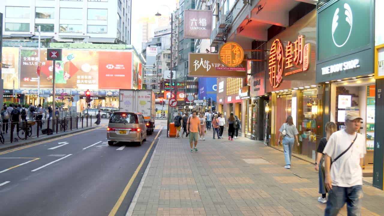 Bustling Hong Kong City Street with Shops and Pedestrians at Night