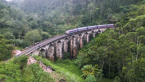 A-train-runs-on-Nine-Arches-Bridge-in-Sri-Lanka,-in-the-middle-of-a-lush-jungle