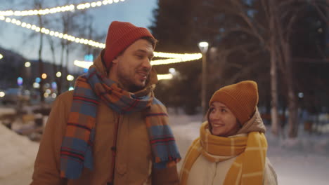 pareja romántica caminando por la calle con guirnaldas