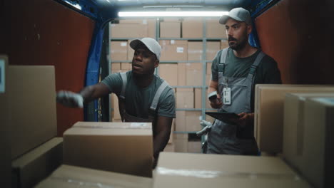 delivery workers scanning and handling packages in a van