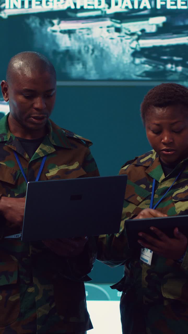 Military Personnel Analyzing Data on Laptop and Tablet in Control Room
