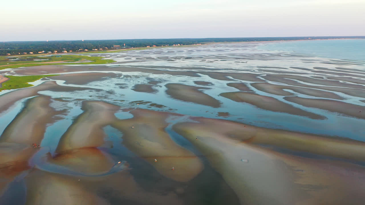 imágenes aéreas de drones de la bahía de cape cod de la playa durante la marea baja con gente caminando, barras de arena y charcos durante la hora dorada