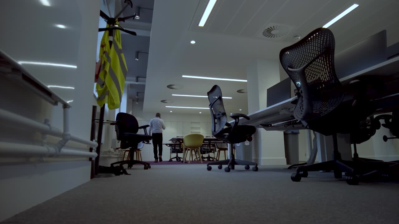 toma en ángulo bajo de un joven ejecutivo de negocios entusiasta y bien vestido, paseando por una oficina hasta una pizarra blanca y tomando notas de sus pensamientos y planes antes de su reunión matutina