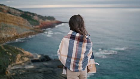 back view relaxed woman in front gray ocean. girl looking on seascape vertical