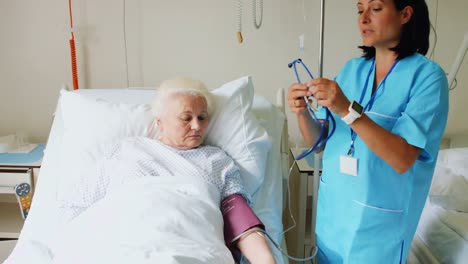 female doctor checking blood pressure of patient