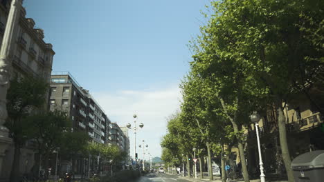 beautiful apartment buildings and green tree alley in downtown of san sebastian