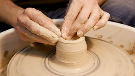 man works with a potter's wheel, only hands