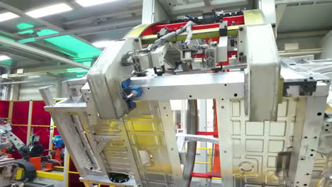 Workshop assembling the body of a car on a conveyor, automotive assembly line with robotic arms crafting a modern silver vehicle body in a bright factory technology for the production of cars.
