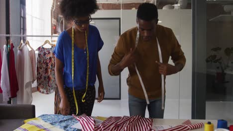 diseñadores de moda afroamericanos masculinos y femeninos tomando medidas de ropa