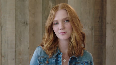 young-stylish-red-head-woman-portrait-of-beautiful-girl-smiling-confident-at-camera-wearing-denim-jacket-wooden-background