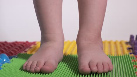 the child does exercises on the orthopedic mat, legs close-up