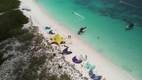 playa crasky with kitesurfers and camp on the sandy beach in los roques, venezuela, aerial view