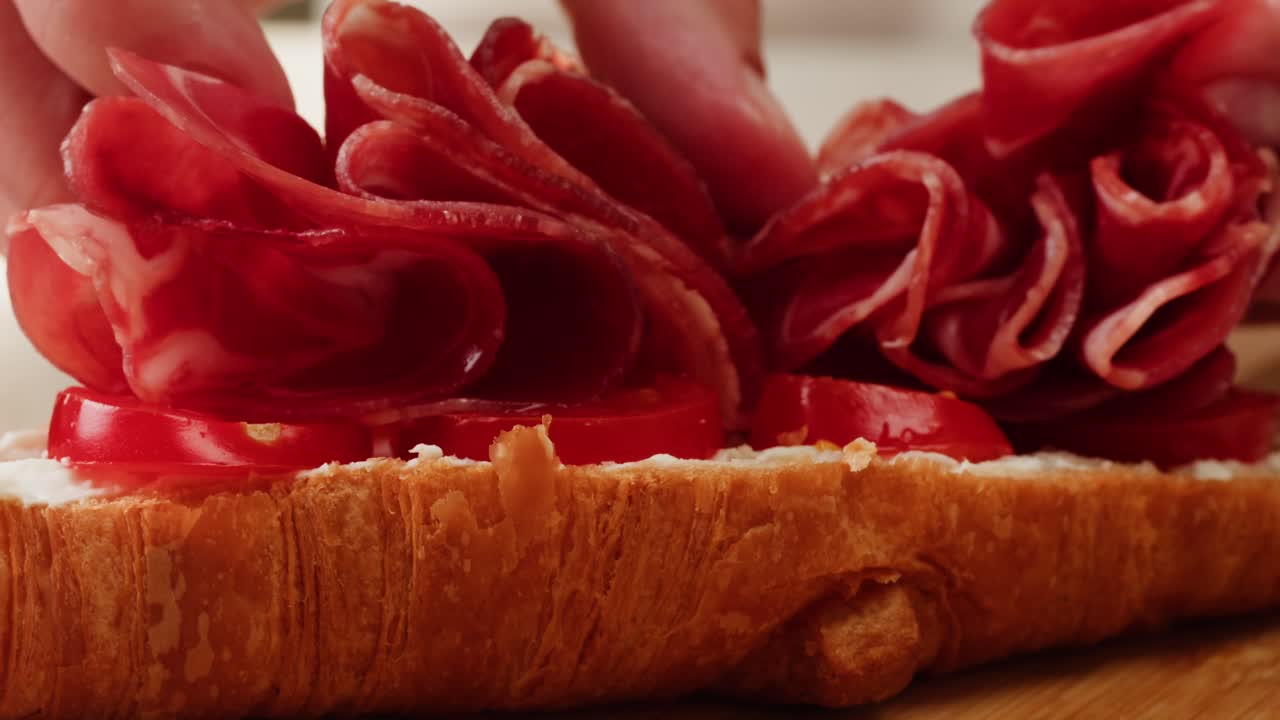 Making a Croissant Sandwich with Ham and Tomatoes