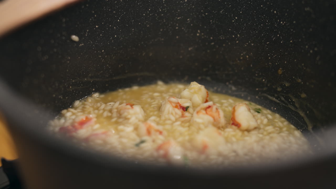 Close up shot of risotto being cooked in a saucepan with shrimps, interior
