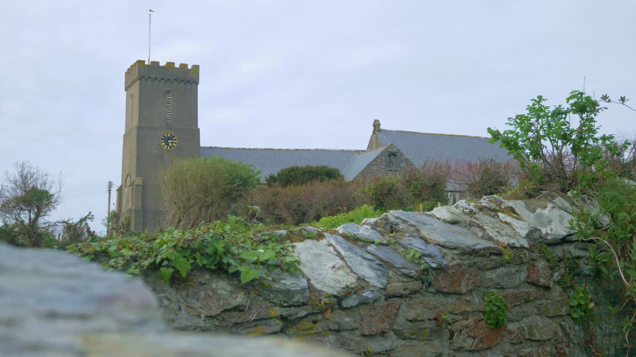 la torre del campanario de la iglesia se cierra en el fondo de la aldea verde en cornualles