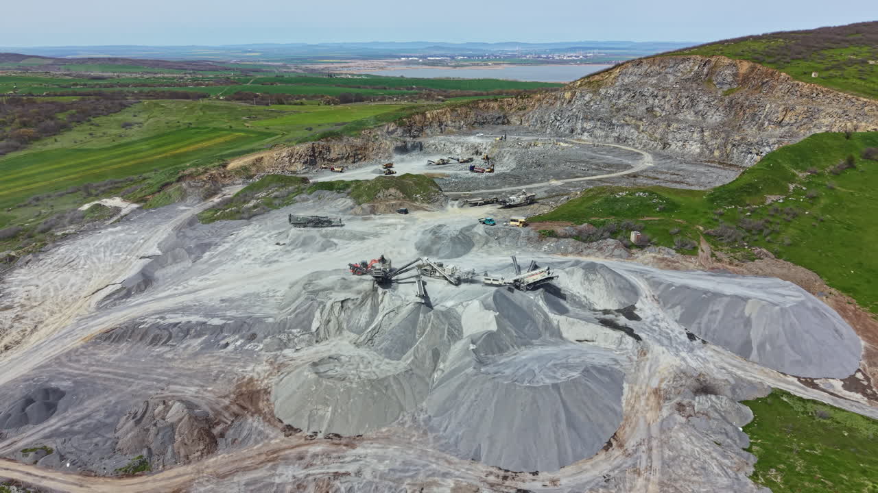 Granite quarry site with machinery and natural landscape in the background during daytime